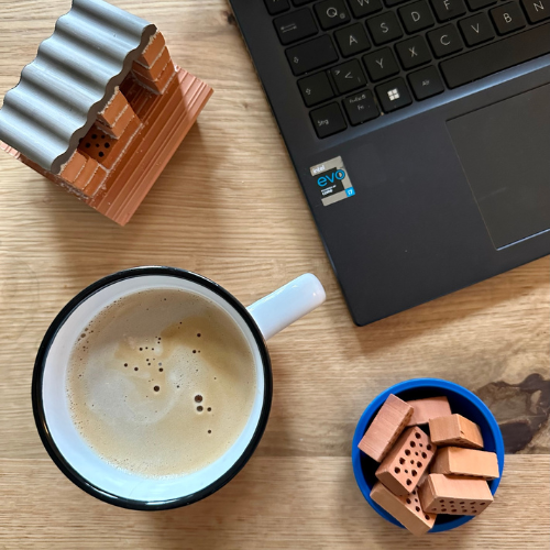 HomeOffice bei teifoc: Kaffee und Mini Ziegelsteine neben dem Laptop