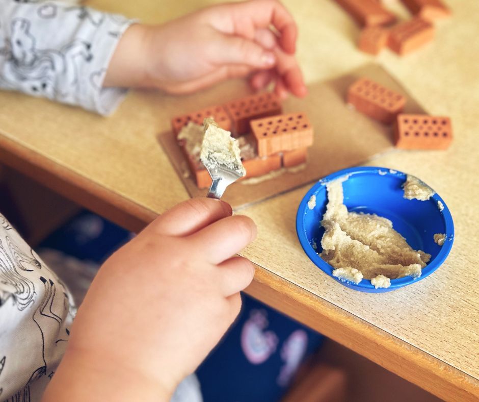 Kind im Kindergarten mauert eine Hundehütte aus Ton
