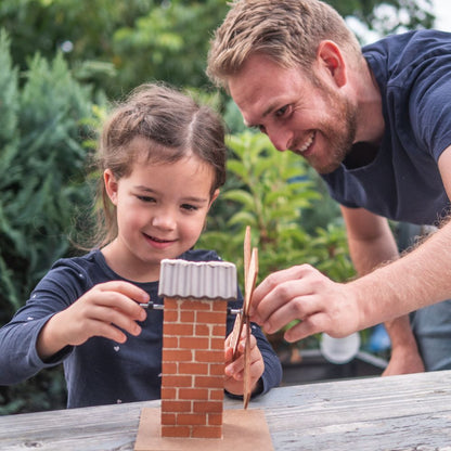 Papa und Tochter bauen gemeinsam lächelnd die teifoc Windmühle